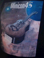Thumbnail of photo of Minicon 46 t-shirt, 2nd design: black shirt with flying guitar city